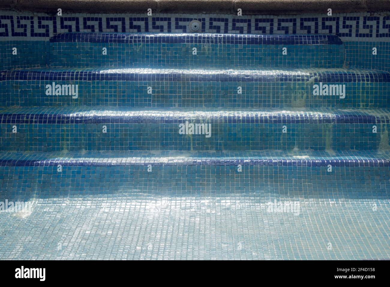 Blue tile swimming pool stairs without water with rests of hydrochloric acid. Stock Photo