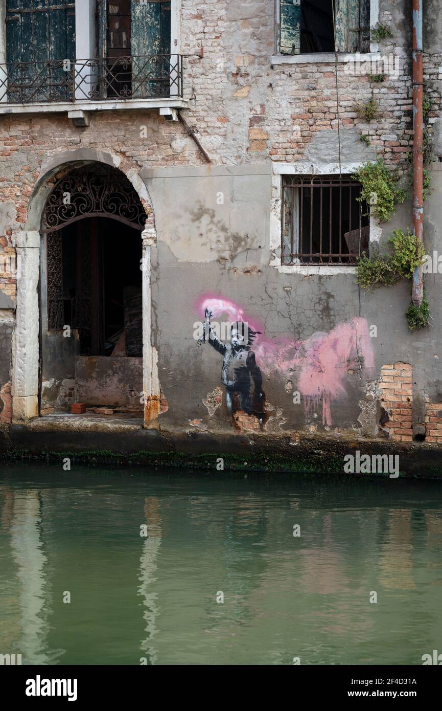 Venice. Italy. Banksy's artwork (May 2019) portraying a migrant child wearing a lifejacket while holding a pink flare, near Campo Santa Margherita in Stock Photo