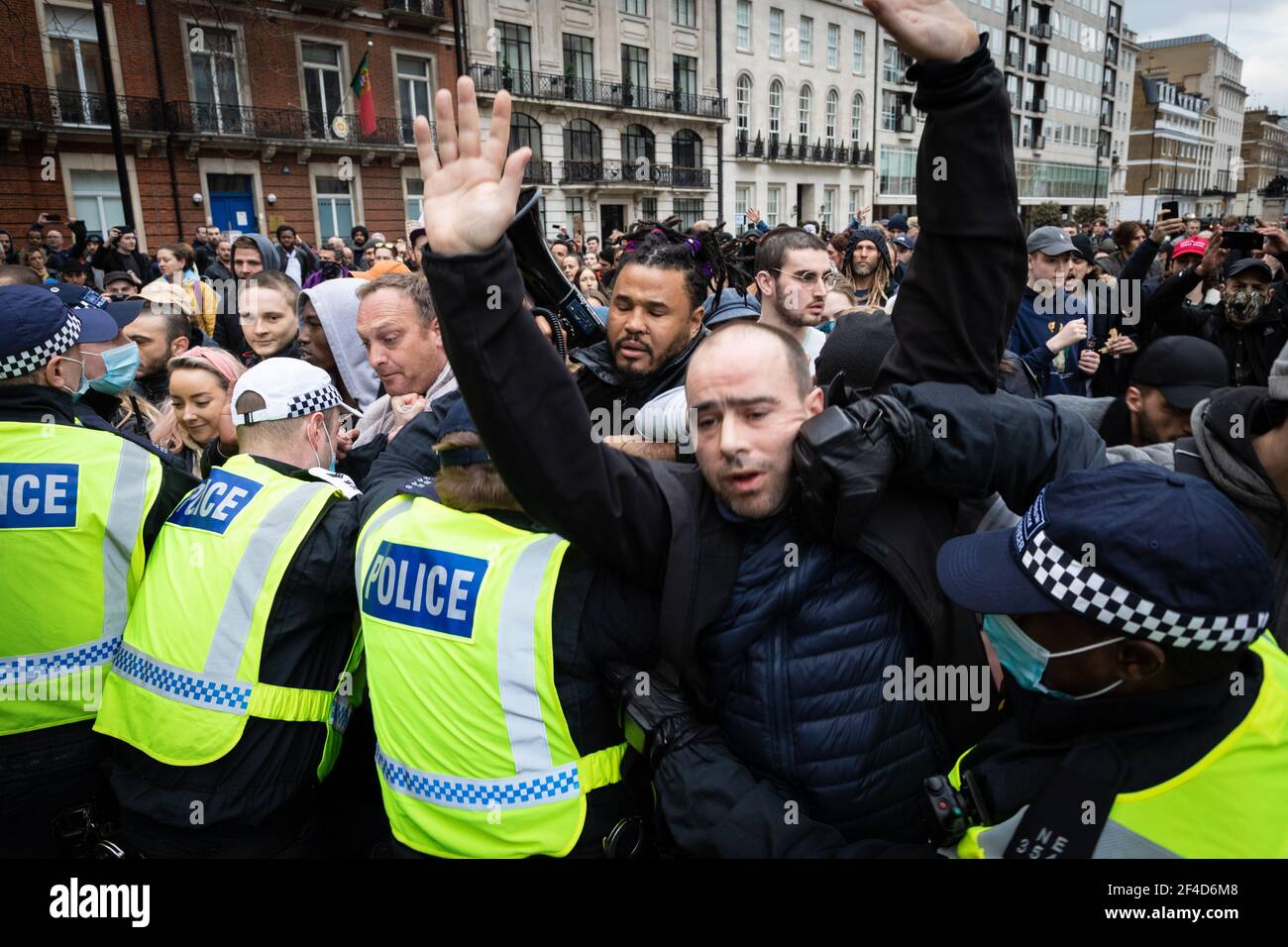 London, UK. 20th Mar, 2021. A protester is caught up in scuffles between the MET police and protesters who were taking part in a anti-lockdown march. A World Wide Rally For Freedom is organised a year after lockdowns were introduced. Credit: Andy Barton/Alamy Live News Stock Photo
