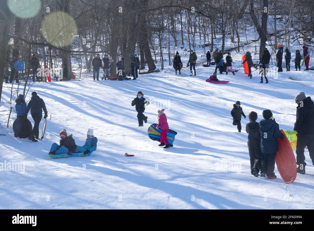Children and families enjoying a day sledding in Prospect Park after a recent winter snow storm in Brooklyn, New York. Stock Photo