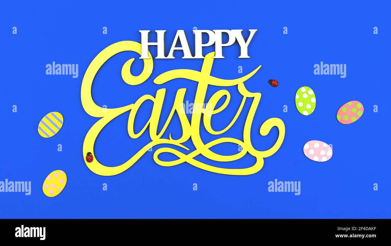 Festive easter greeting card with text Happy Easter and eggs on blue background Stock Photo