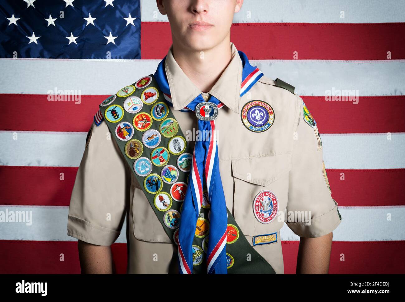 Portrait of a teenage boy scout standing in front of an American flag Stock Photo