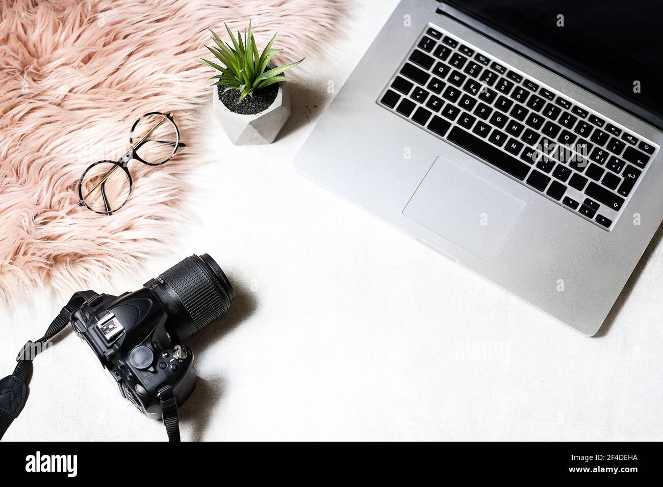 flat lay of workspace with laptop eyeglasses photo camera on white