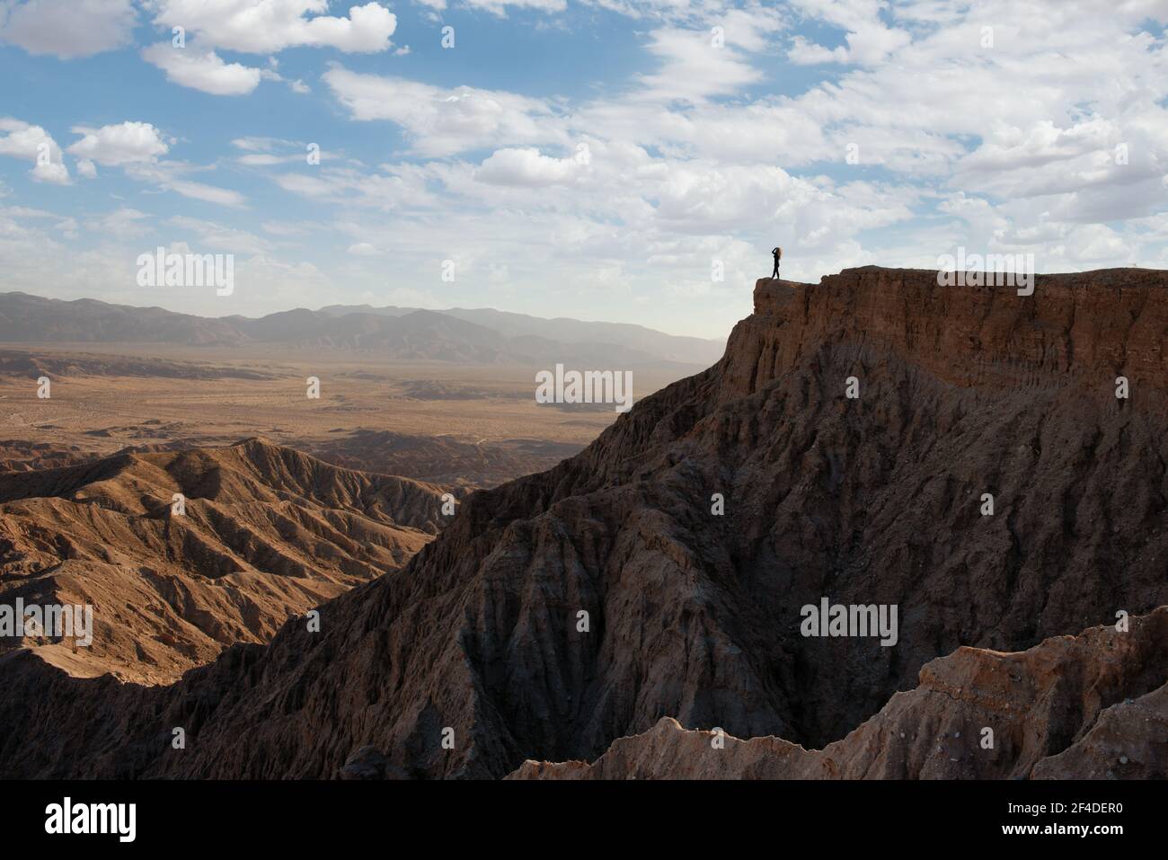 Woman standing on mountain looking at badlands mountain view, Anza Borrego Desert State Park, California, USA Stock Photo