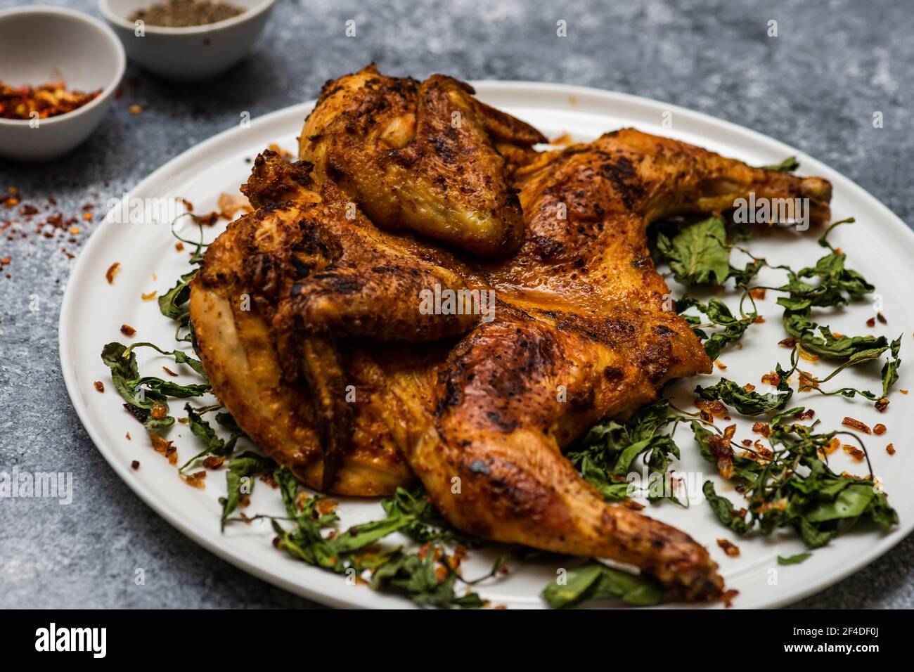 pan fried chicken tabaka with fried coriander leaves and
