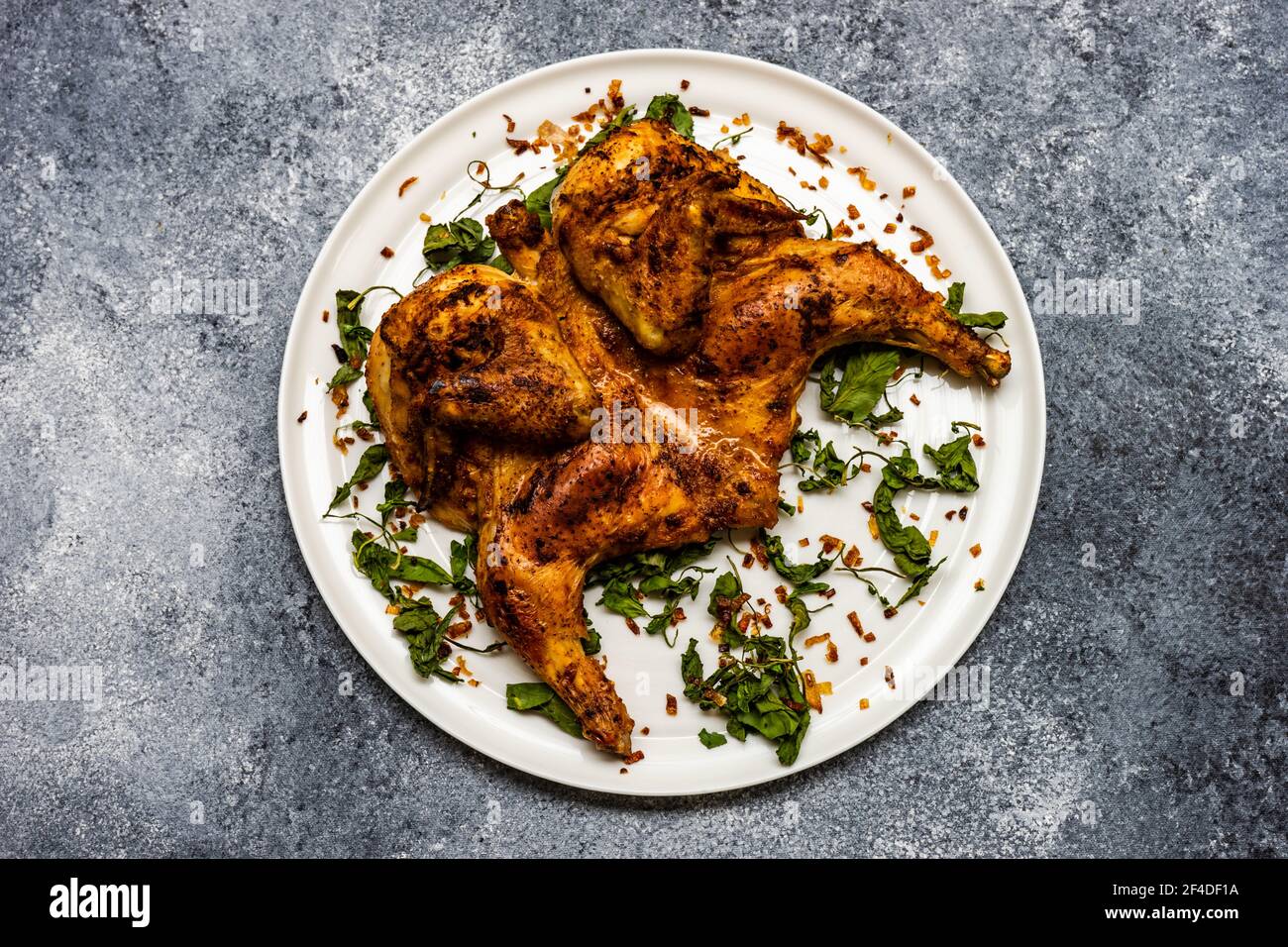 pan fried chicken tabaka with fried coriander leaves and