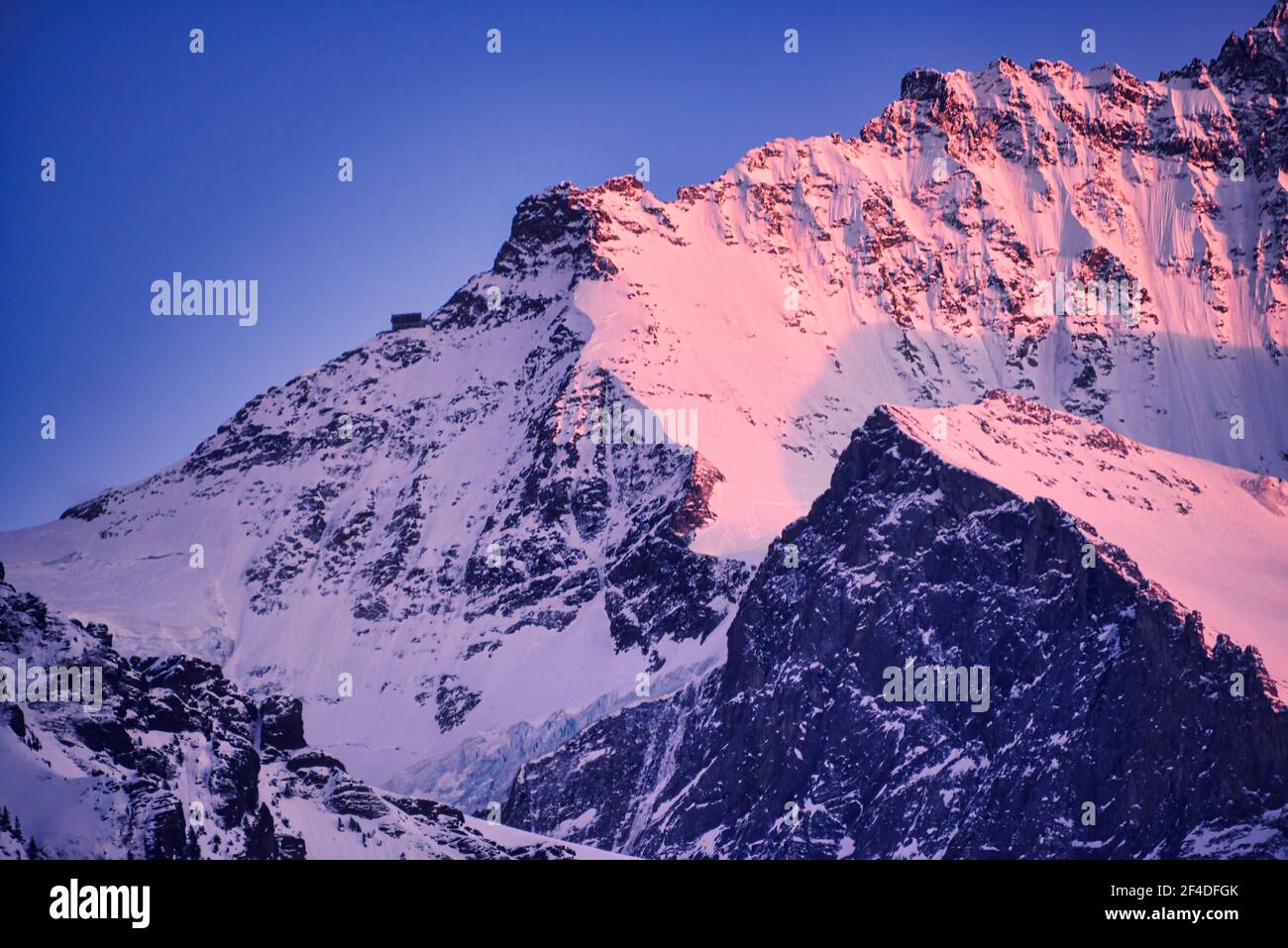 Alpine snowcapped mountain peak at sunset, Switzerland Stock Photo
