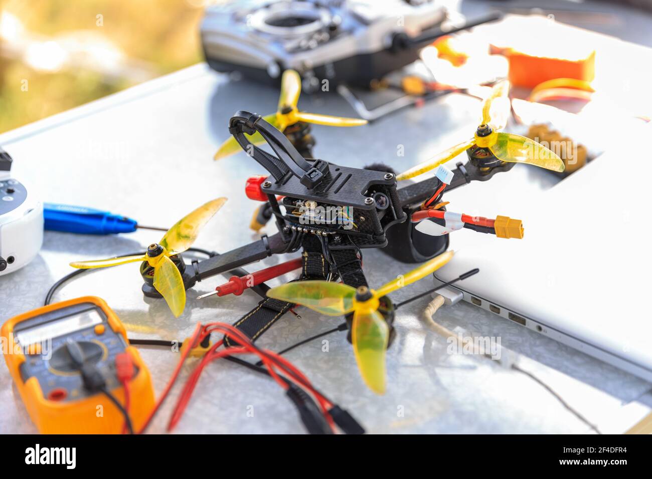 A fpv high-speed racing drone copter and remote telemetry controller lying on the table Stock Photo