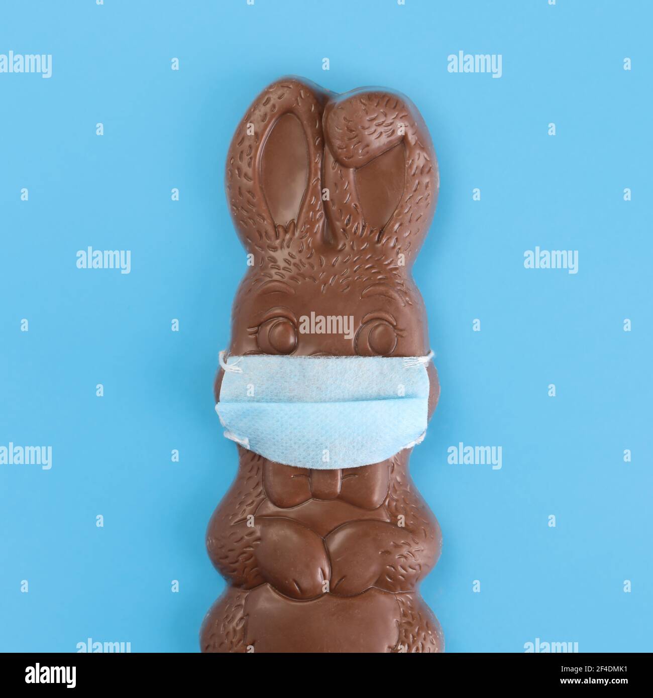 Chocolate Easter bunny wearing a medical mask. Social distancing Easter celebrations due to Covid 19 or Coronavirus safety restrictions. Stock Photo