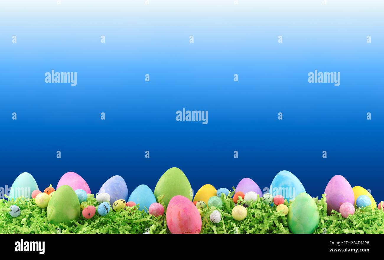 Painted Easter eggs and decorations on arranged on Easter grass with blank copyspace for text. Stock Photo