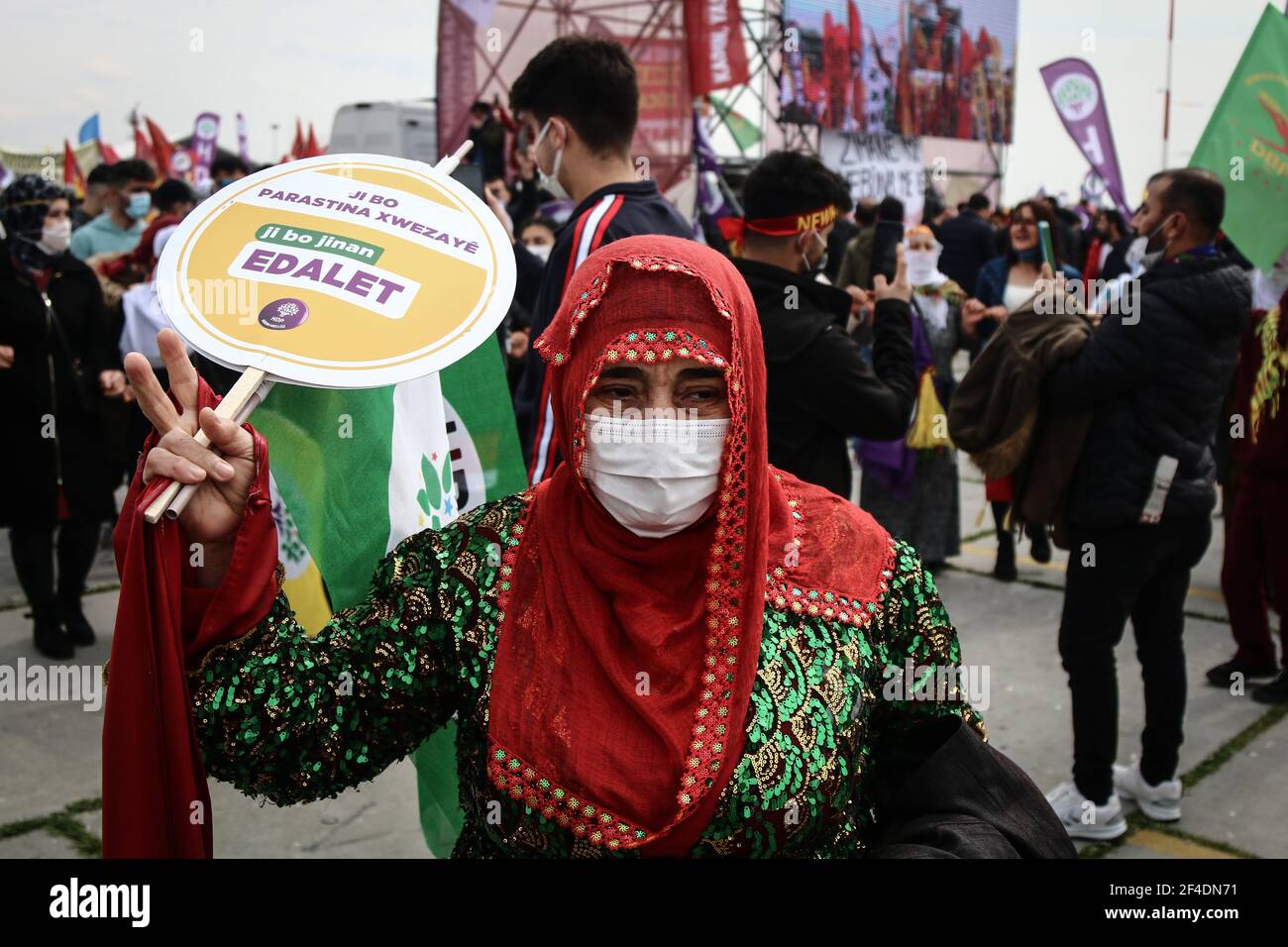 A Kurdish woman wearing a traditional dress making a victory sign ...