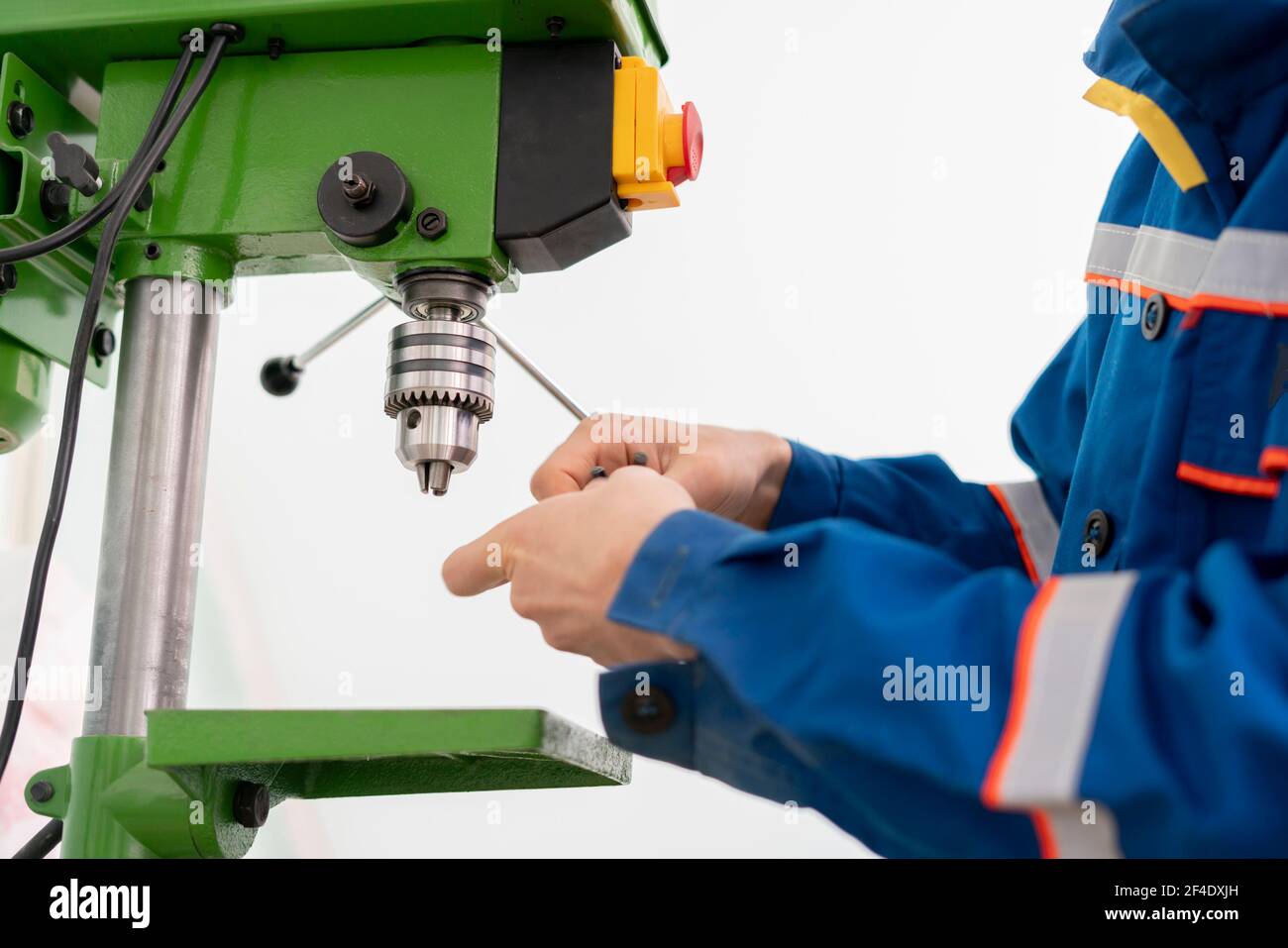 a close up young male worker using a drill machine on the factory Stock Photo