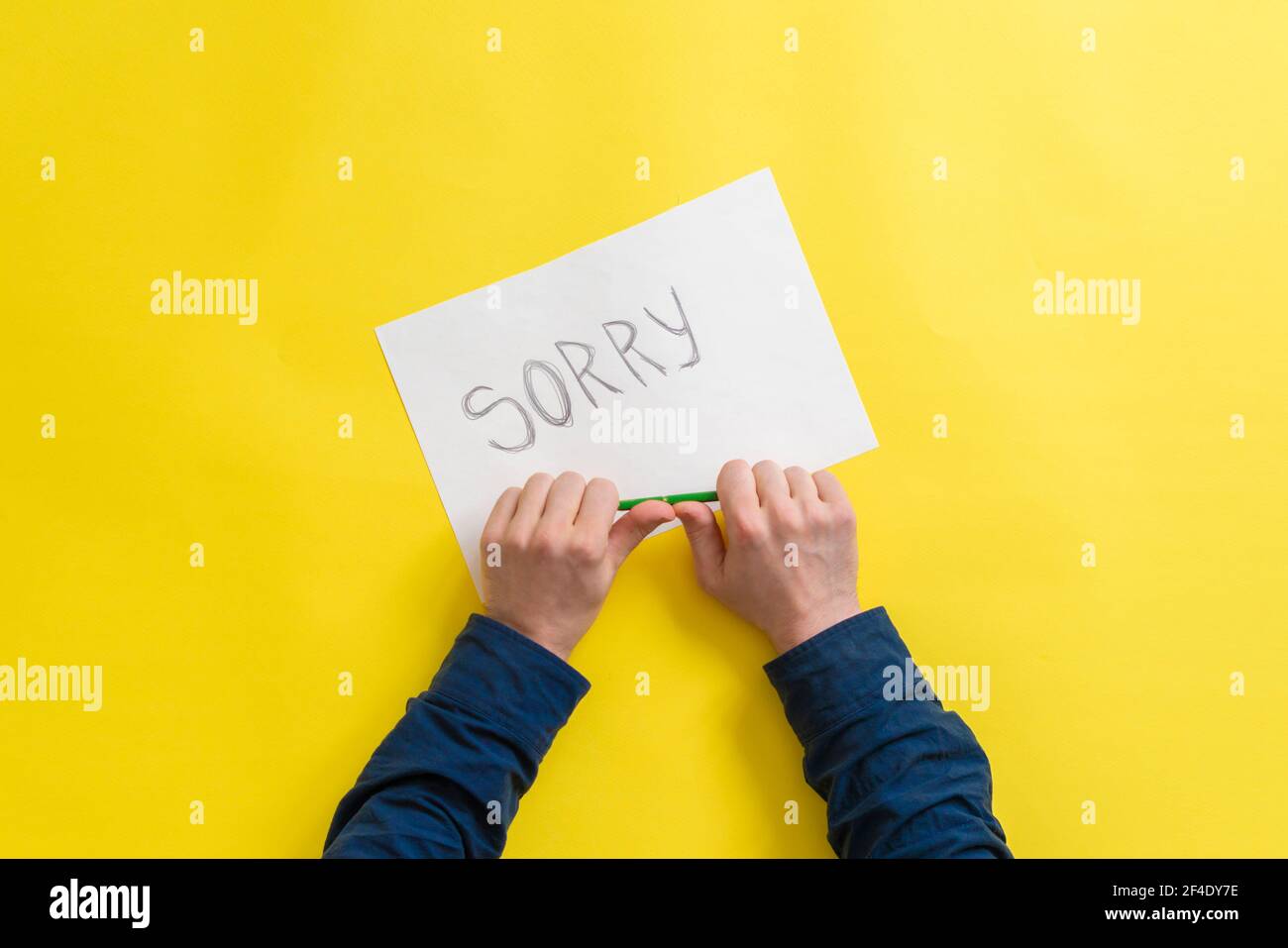 a person hands holding a paper sheet with the sorry word Stock Photo