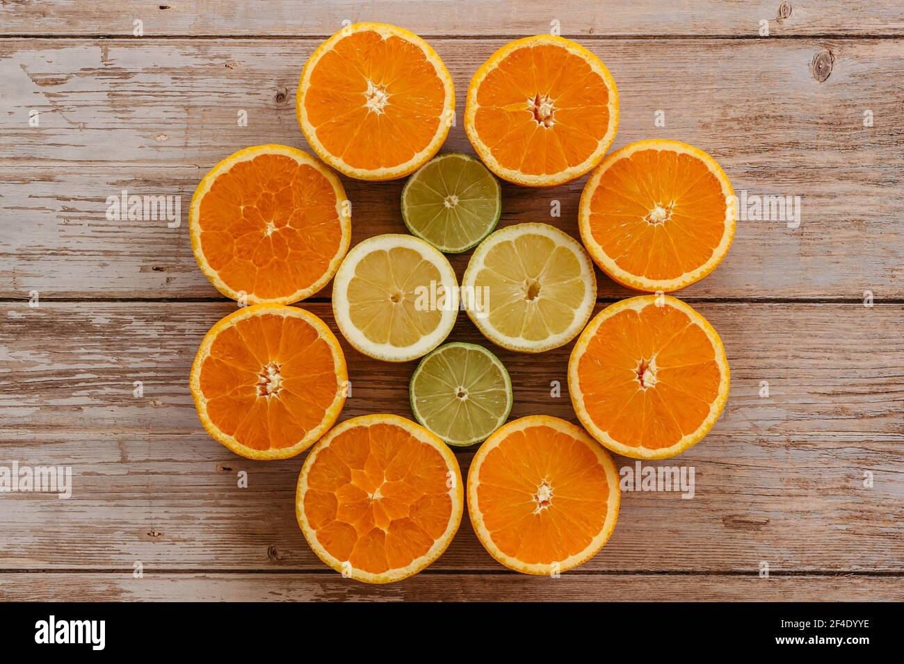 Oranges,limes and lemons slides on wooden table view from above. Beautiful background with fresh fruit half cut.Healthy eating vitamin C.Summer tropic Stock Photo