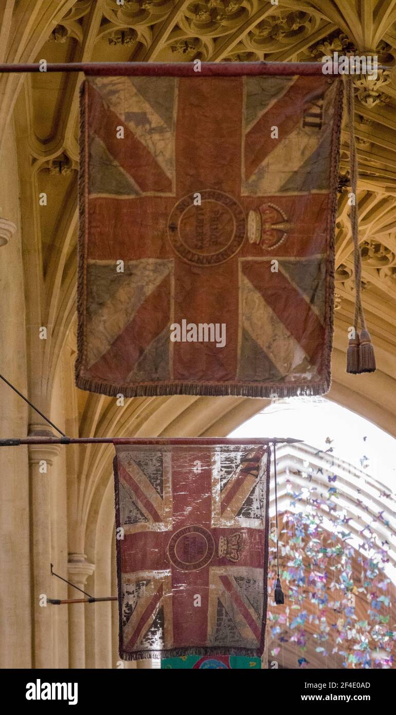 Detail of two old flags hanging in the interior of Bath Abbey on a sunny day Stock Photo