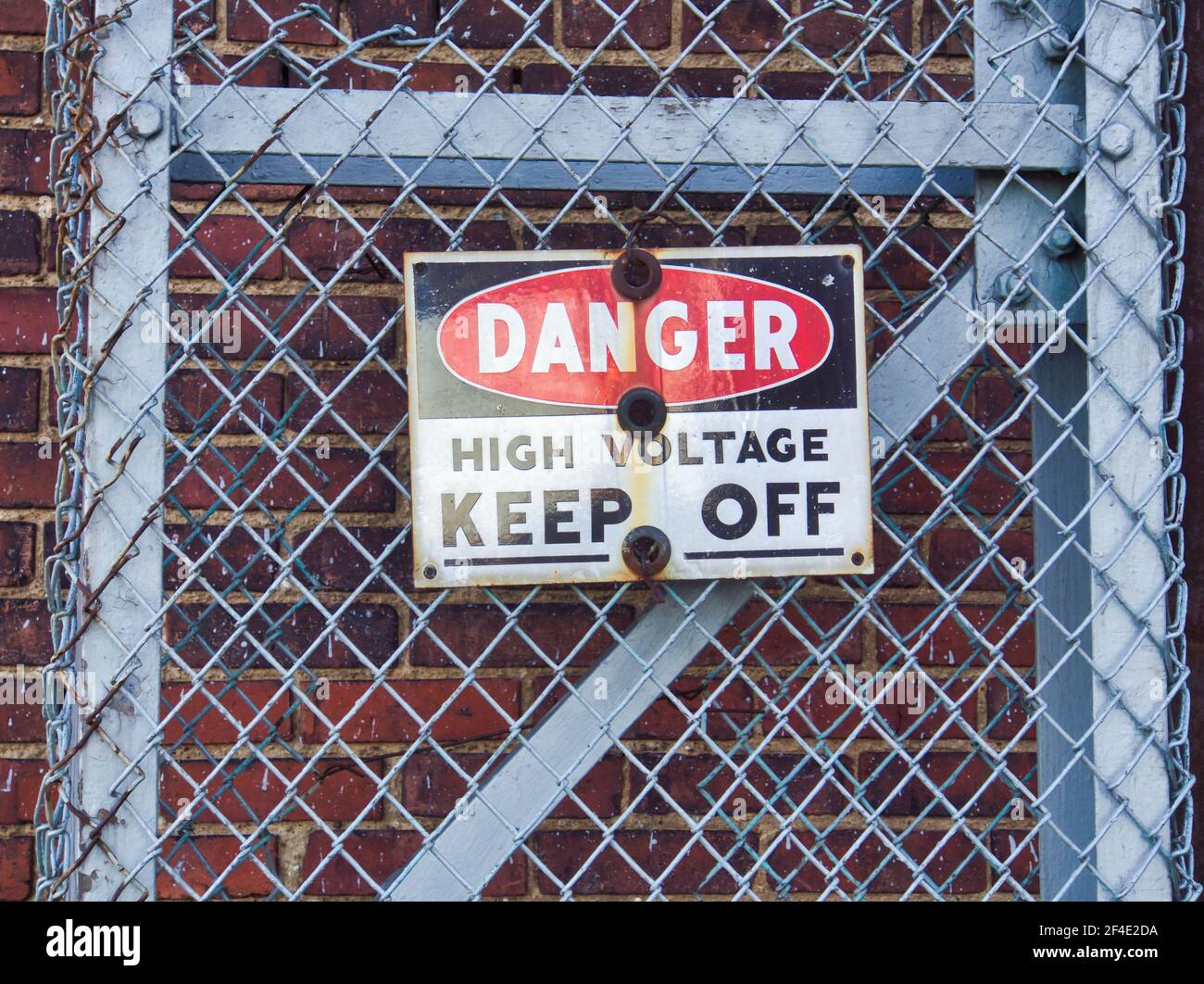 Danger high voltage sign on fence Stock Photo