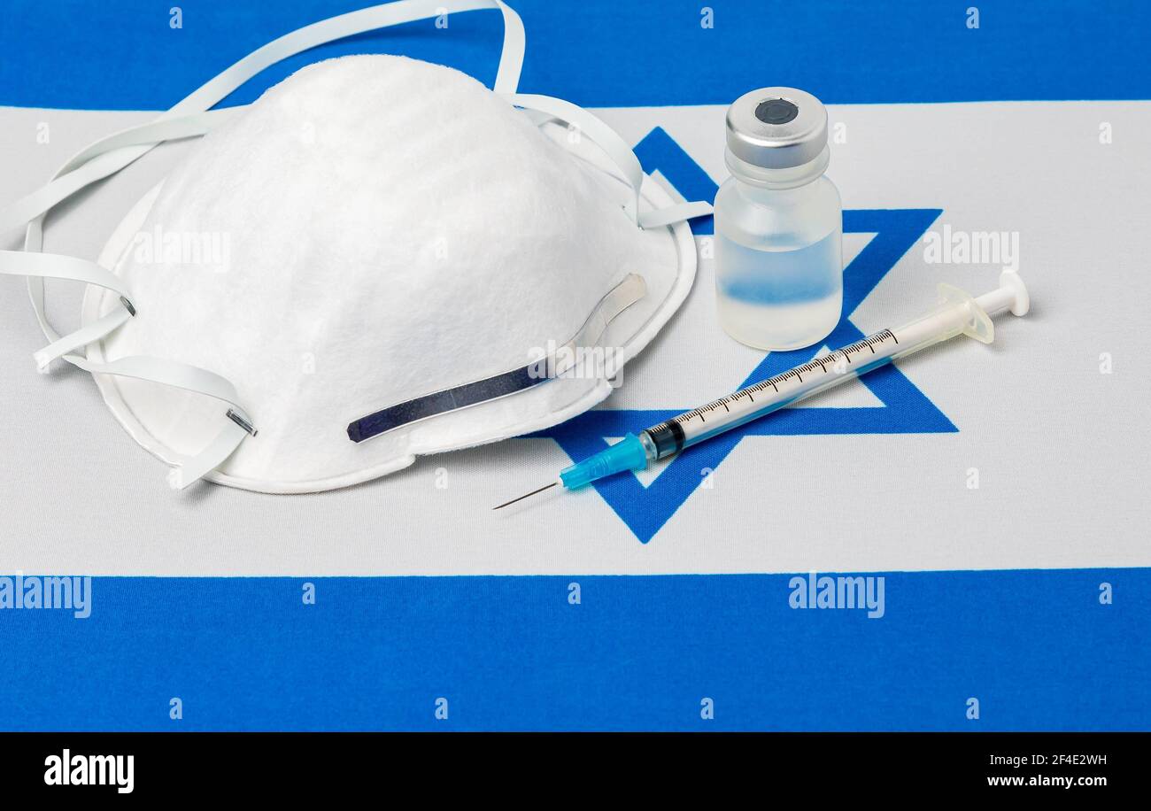 Israel flag, n95 face mask, needle syringe and vial. Concept of Covid-19 coronavirus vaccine distribution, supply shortage and healthcare crisis Stock Photo