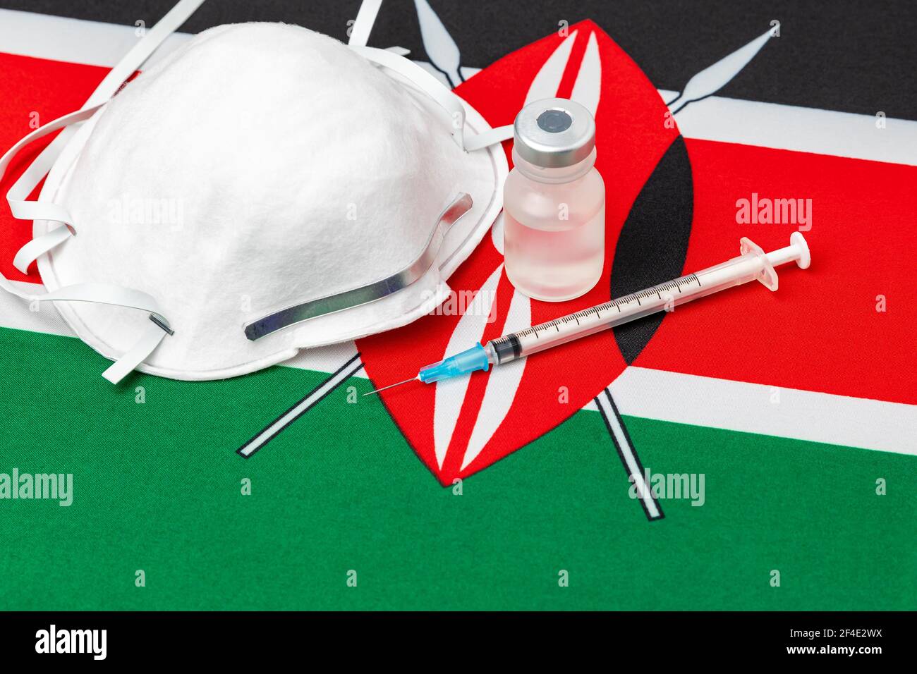 Kenya flag, n95 face mask, needle syringe and vial. Concept of Covid-19 coronavirus vaccine distribution, supply shortage and healthcare crisis Stock Photo