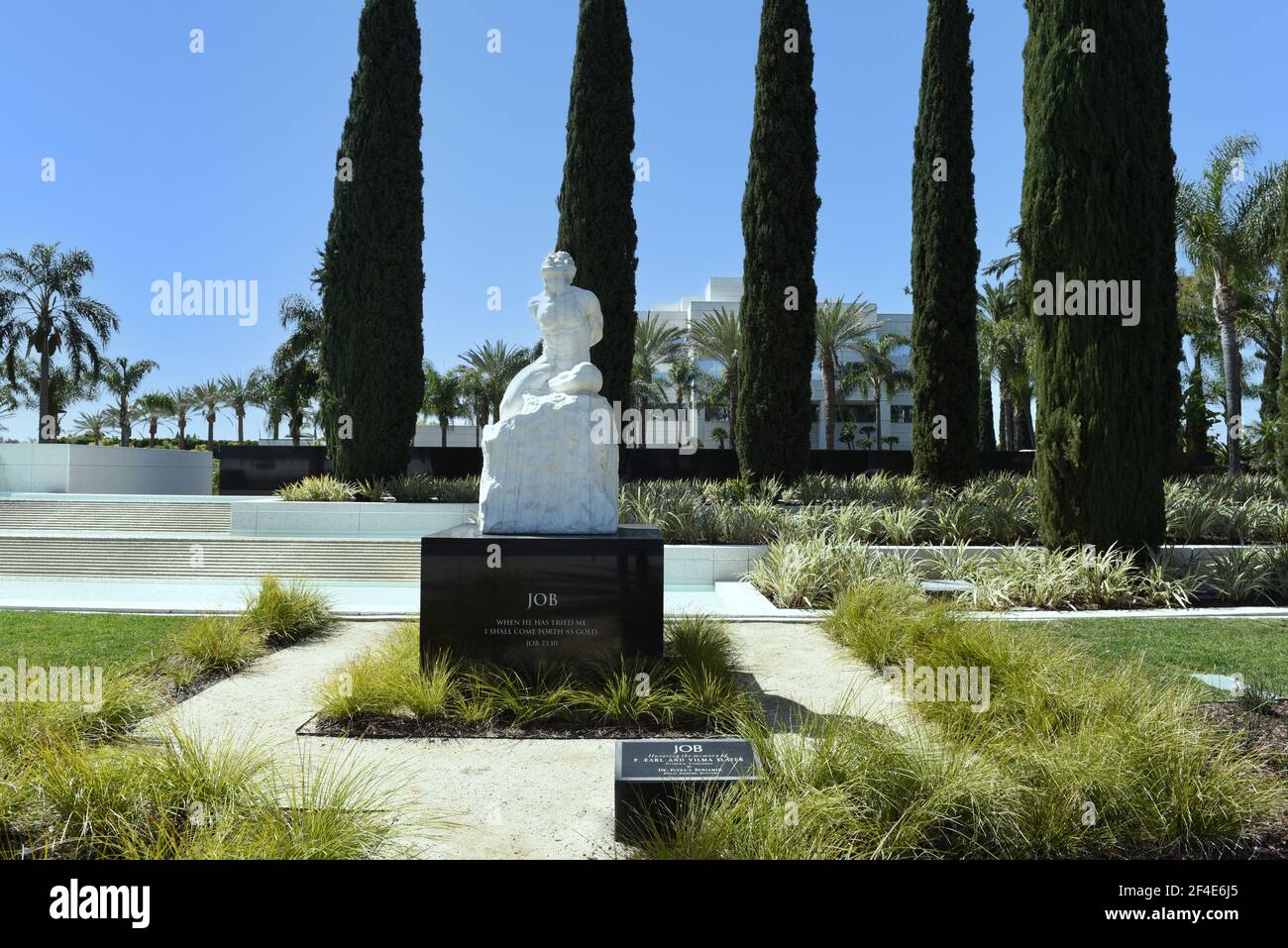 GARDEN GROVE, CALIFORNIA - 20 MAR 2021: Statue of Job with the Christ Cathedral Academy in the background. Stock Photo