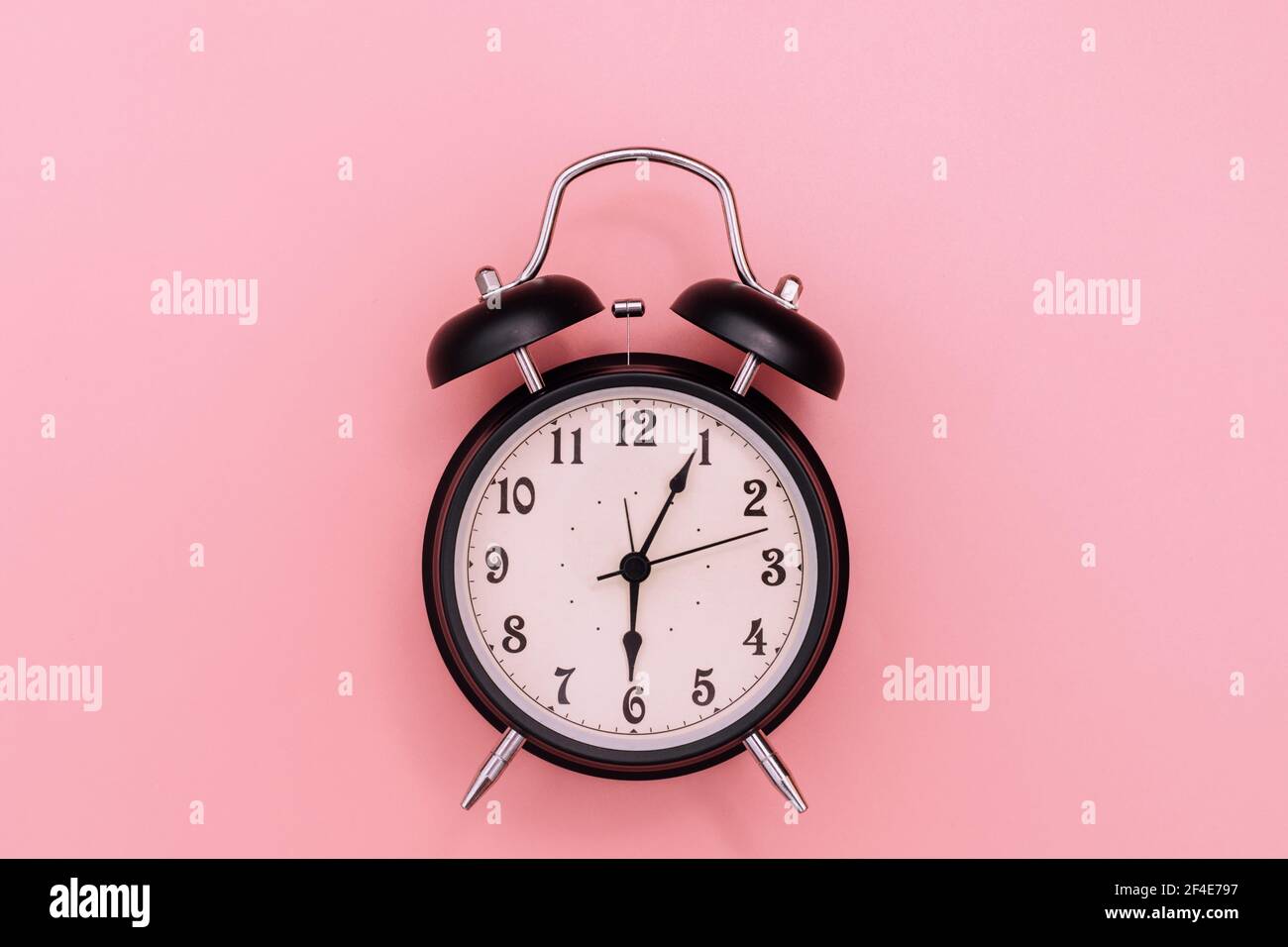 Black alarm clock on pink background Stock Photo