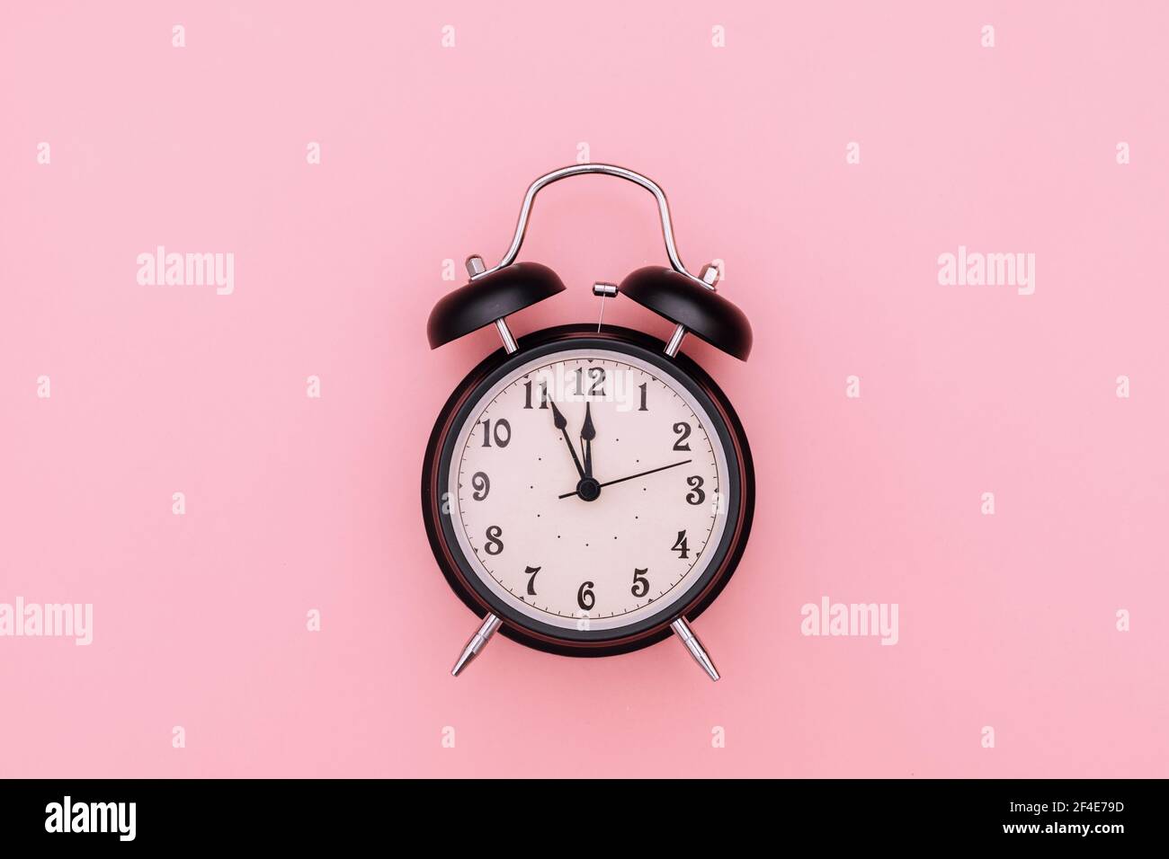 Black alarm clock on pink background Stock Photo