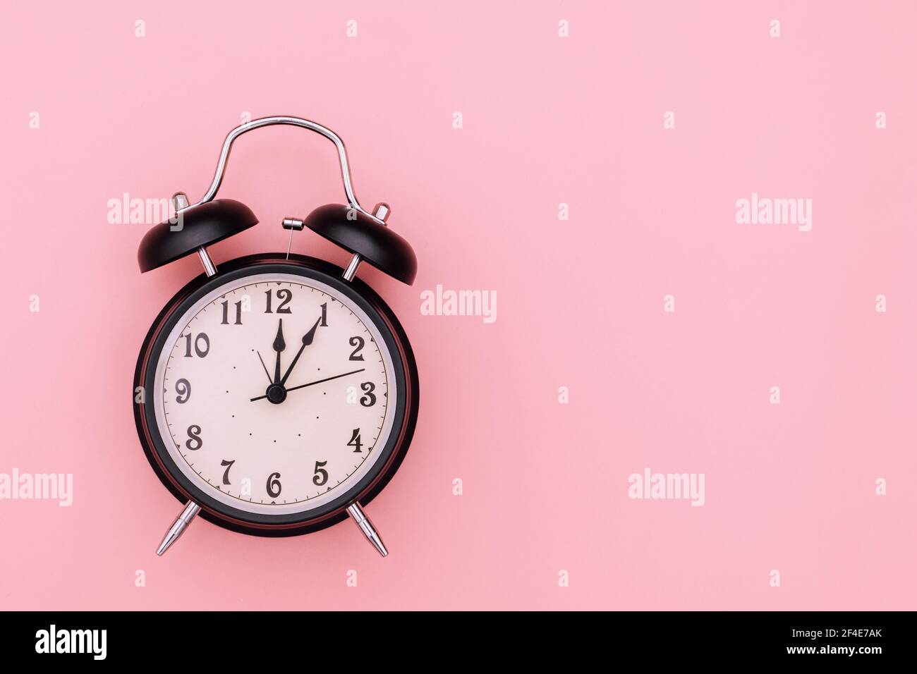 Black alarm clock on pink background Stock Photo