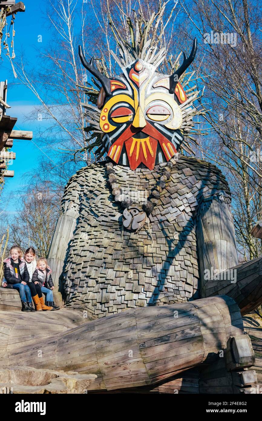 (210321) -- BOOM, March 21, 2021 (Xinhua) -- Children pose for photos with a 'troll' at the De Schorre forest park in Boom, Belgium, March 20, 2021. Danish artist Thomas Dambo and his team built seven giant 'trolls' from reclaimed wood at the De Schorre forest park in northern Belgium in 2019. These giant wooden sculptures are dotted around the forest. The United Nations General Assembly proclaimed March 21 as the International Day of Forests which celebrates and creates awareness on the importance of all types of forests and on the need to preserve and care for the world's woodlands. Thi Stock Photo