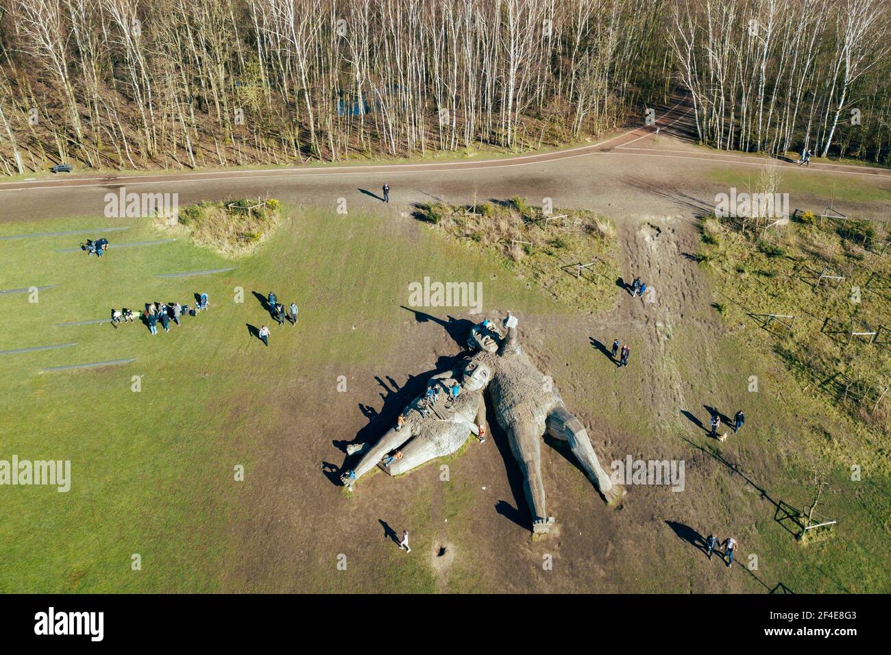 (210321) -- BOOM, March 21, 2021 (Xinhua) -- Aerial photo taken on March 20, 2021 shows people viewing two 'trolls' at the De Schorre forest park in Boom, Belgium. Danish artist Thomas Dambo and his team built seven giant 'trolls' from reclaimed wood at the De Schorre forest park in northern Belgium in 2019. These giant wooden sculptures are dotted around the forest. The United Nations General Assembly proclaimed March 21 as the International Day of Forests which celebrates and creates awareness on the importance of all types of forests and on the need to preserve and care for the world's Stock Photo