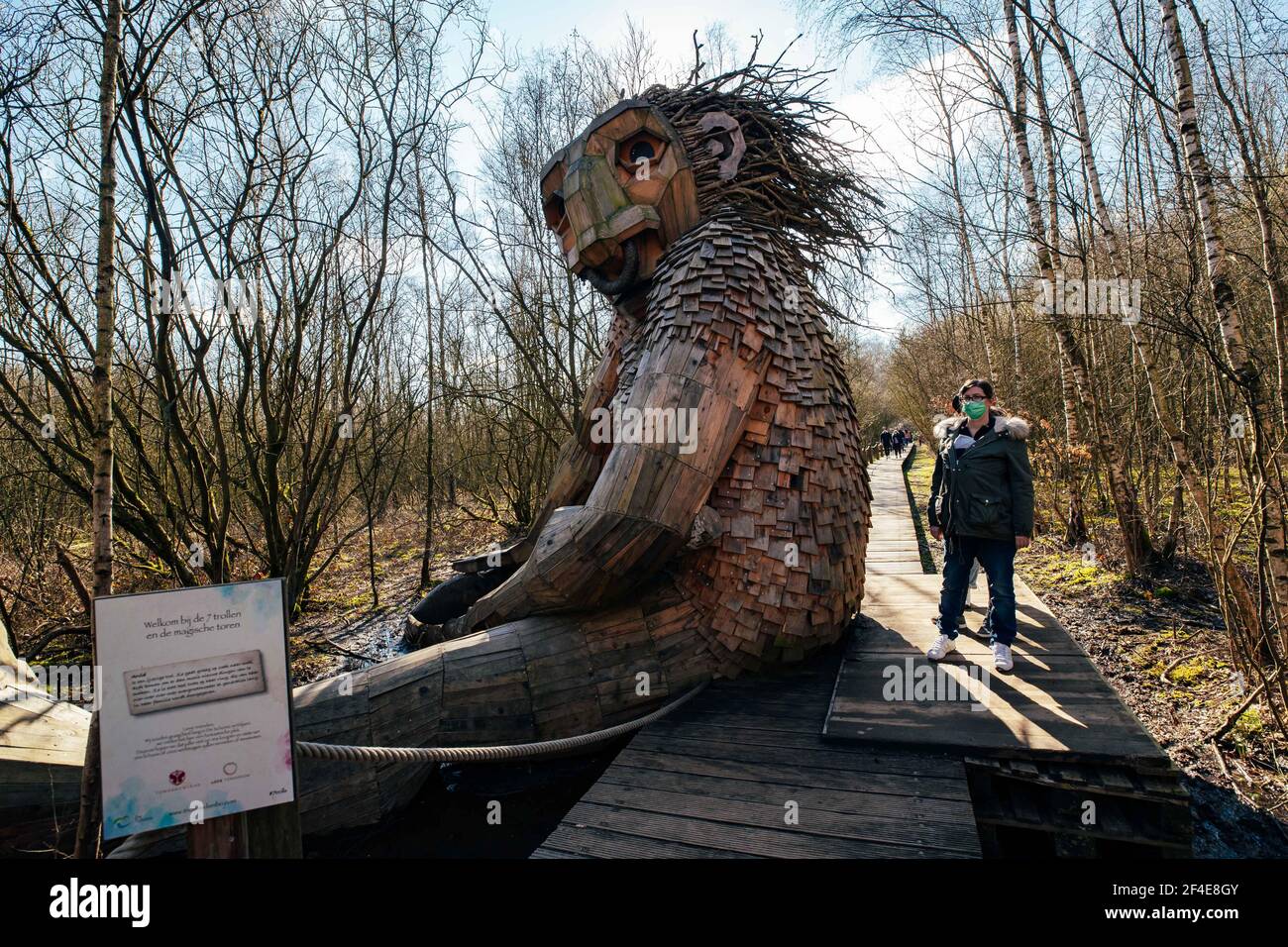 (210321) -- BOOM, March 21, 2021 (Xinhua) -- People view a 'troll' at the De Schorre forest park in Boom, Belgium, March 20, 2021. Danish artist Thomas Dambo and his team built seven giant 'trolls' from reclaimed wood at the De Schorre forest park in northern Belgium in 2019. These giant wooden sculptures are dotted around the forest. The United Nations General Assembly proclaimed March 21 as the International Day of Forests which celebrates and creates awareness on the importance of all types of forests and on the need to preserve and care for the world's woodlands. This year the theme f Stock Photo
