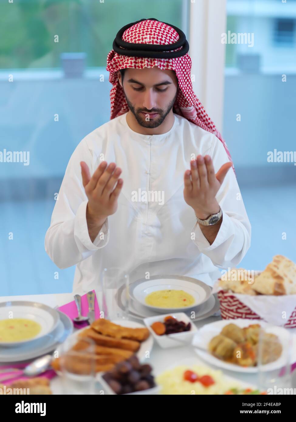 Muslim man making iftar dua to break fasting during Ramadan Stock Photo