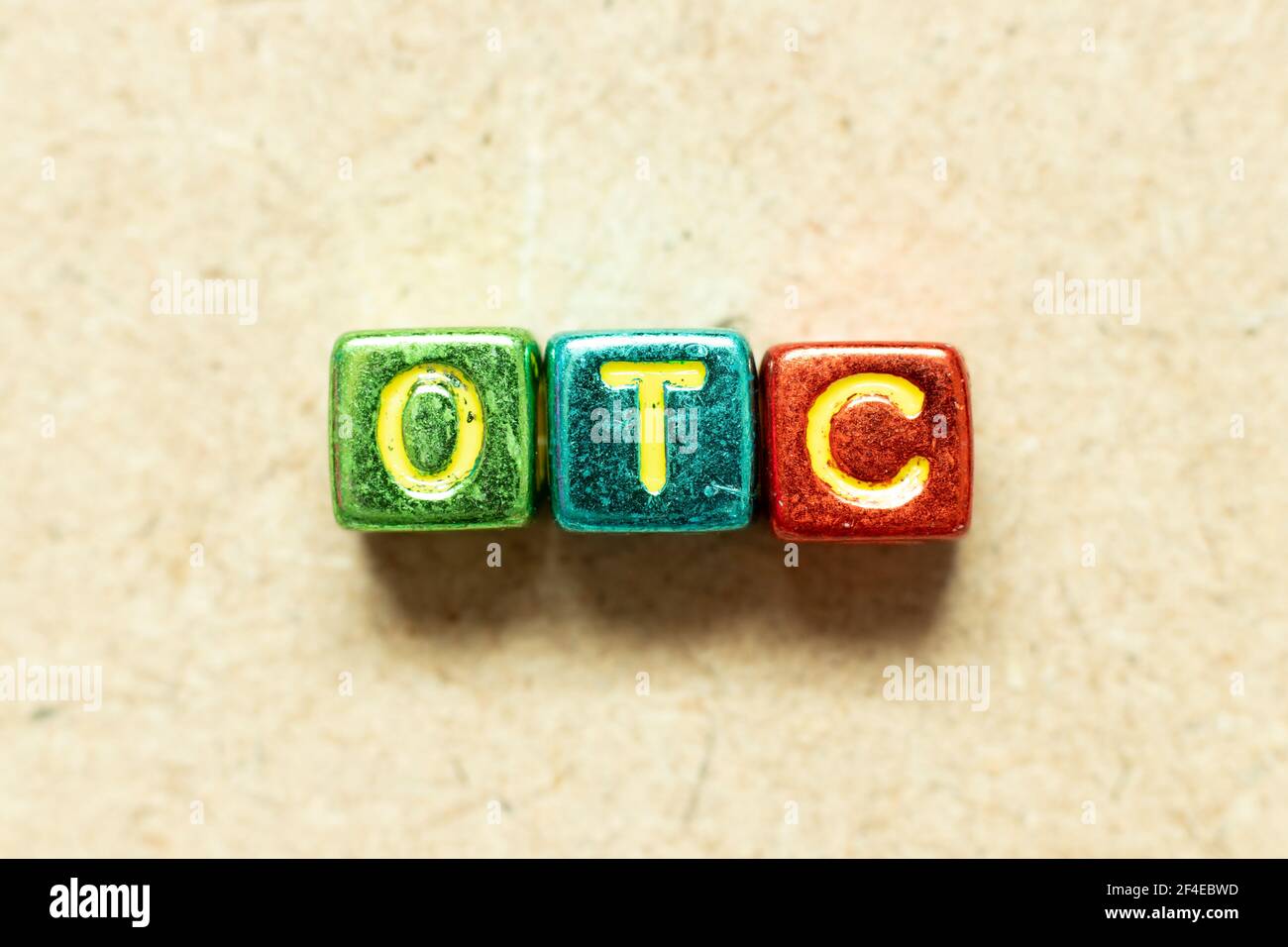 Metallic color alphabet letter block in word OTC (Abbreviation of over the counter)  on wood background Stock Photo
