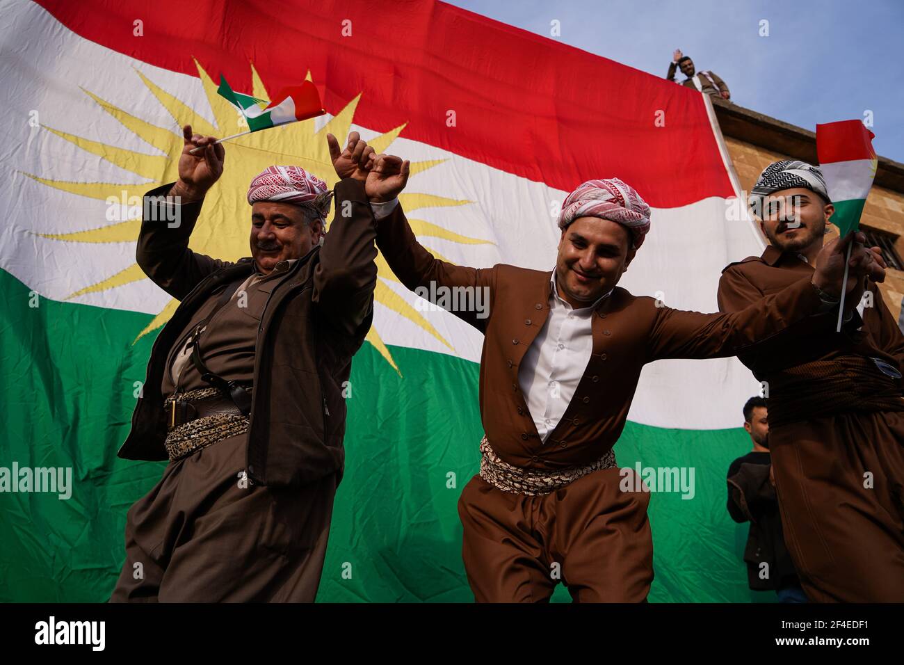 Iraqi Kurds dancing next to the Kurdistan flag during the Nowruz ...