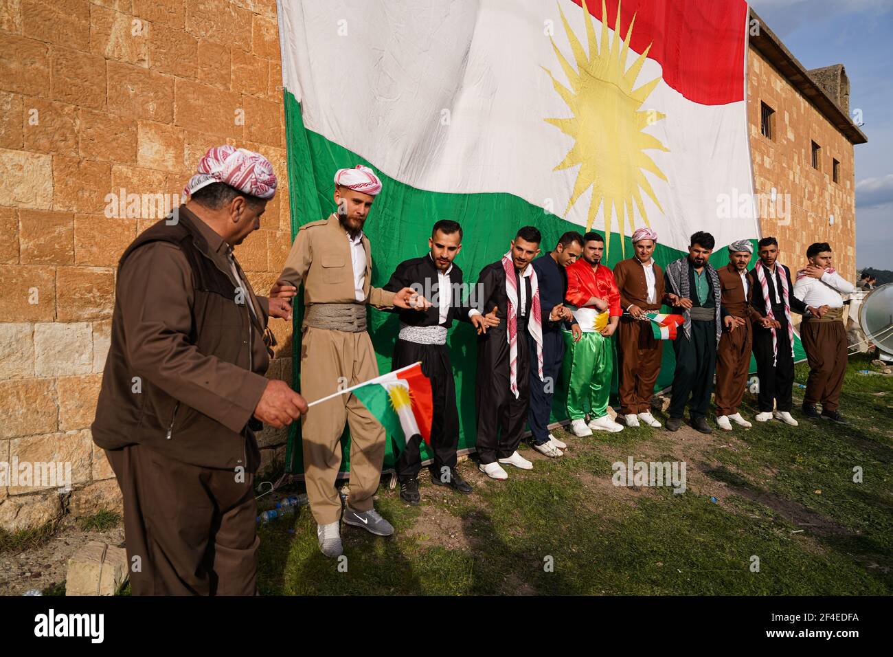 Iraqi Kurds dancing next to the Kurdistan flag during the Nowruz ...