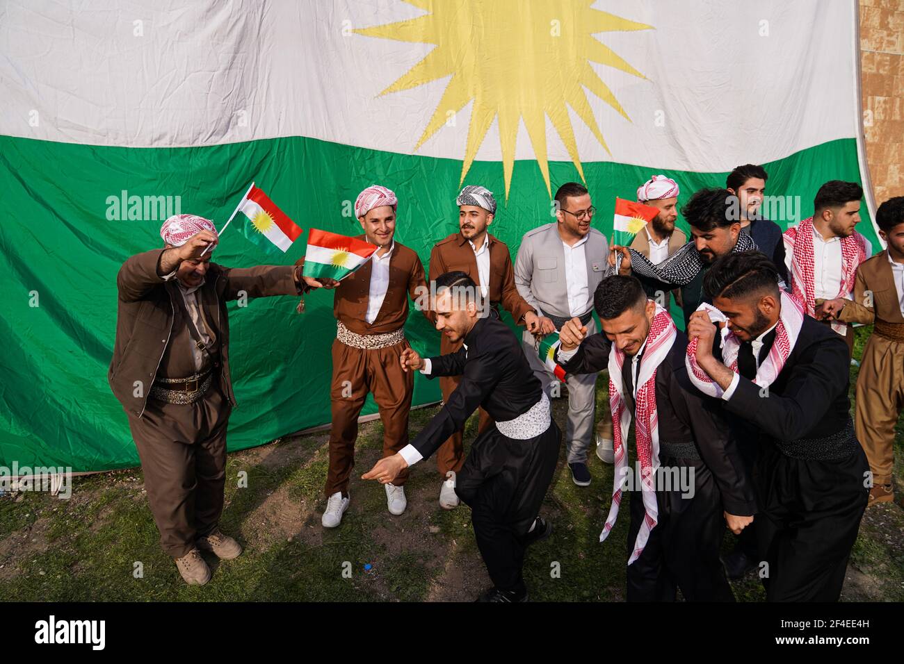 Iraqi Kurds dancing next to the Kurdistan flag during the Nowruz ...