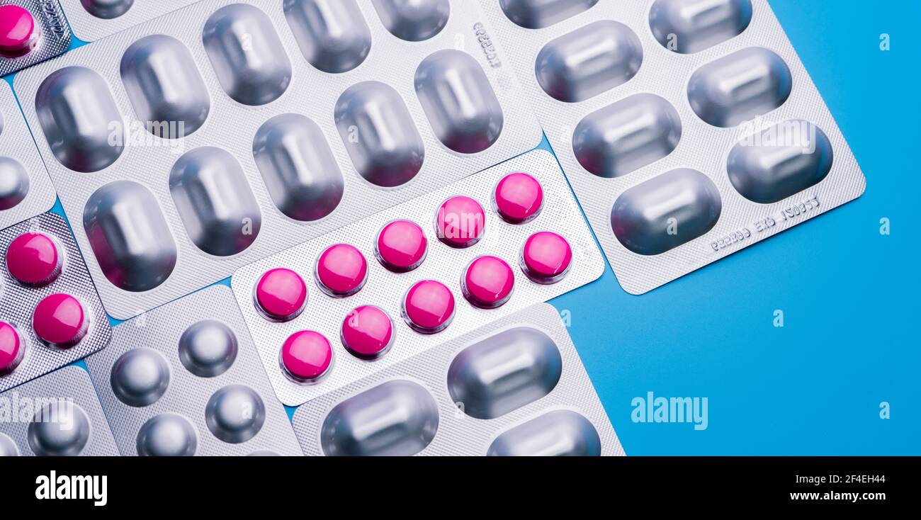 Pink tablets in blister pack and silver aluminium foil pack for capsule and tablets pills in pharmaceutical industry. Pharmaceutical package Stock Photo