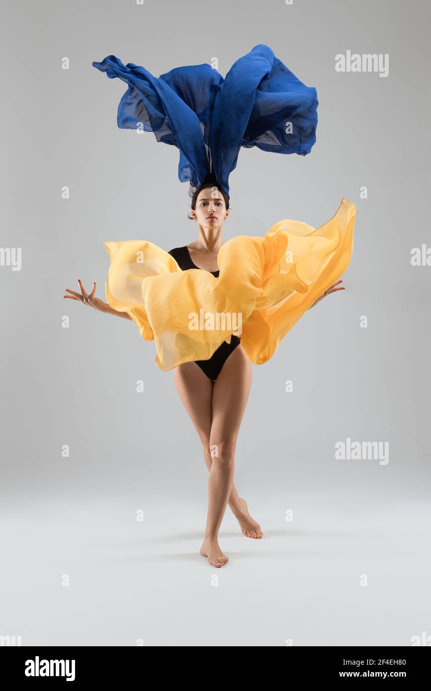 Graceful woman dancing with colorful cloth in studio Stock Photo