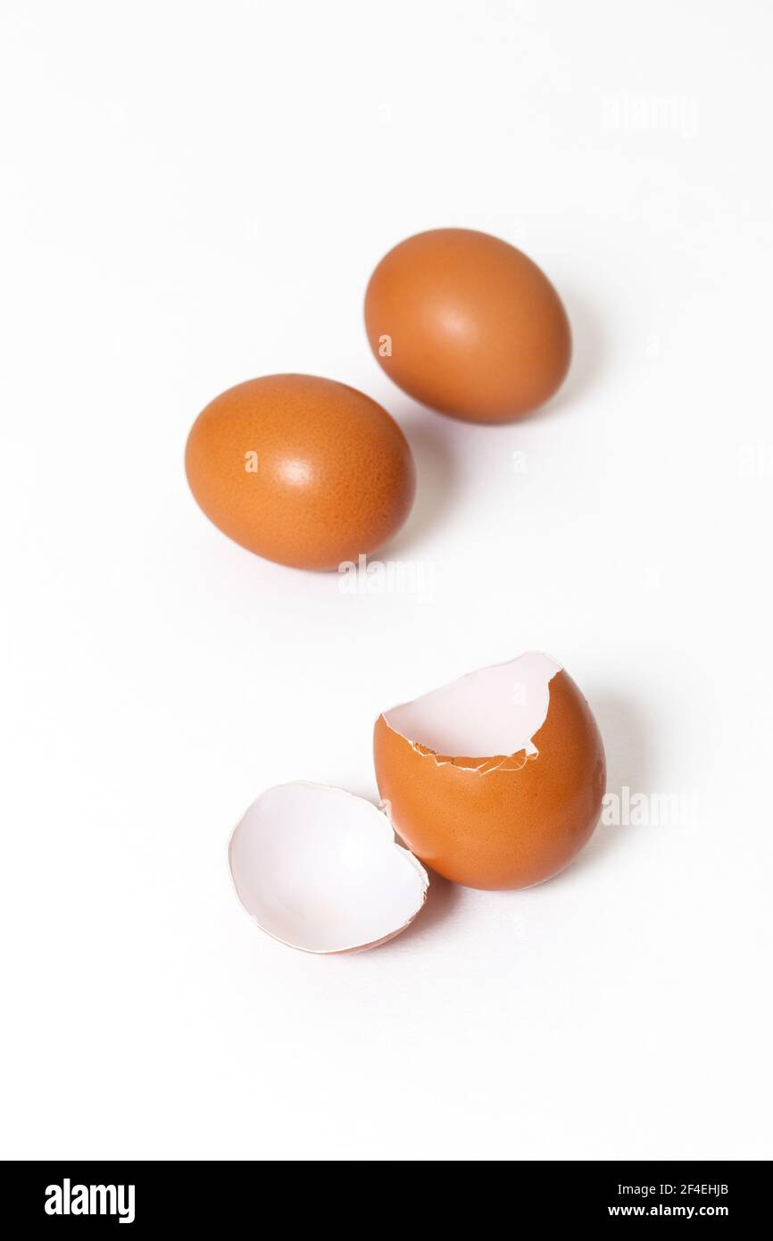 Fresh chicken whole eggs and a broken egg isolated on white background Stock Photo