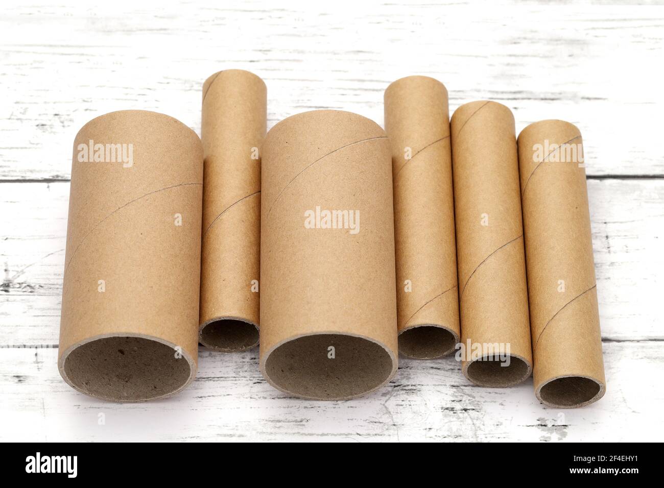 Row of Cardboard cylinders on a white wooden table Stock Photo