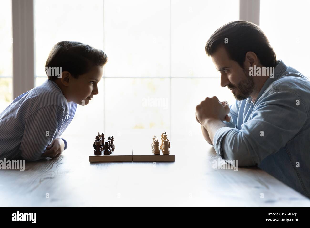 Young Caucasian dad and small son ready for chess match Stock Photo