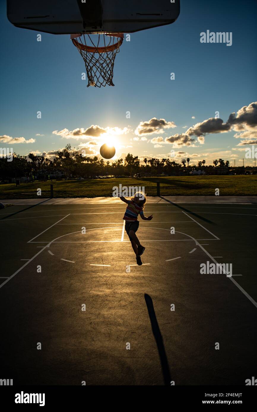 Kid playing basketball. Cute little boy child jumping with basket ball