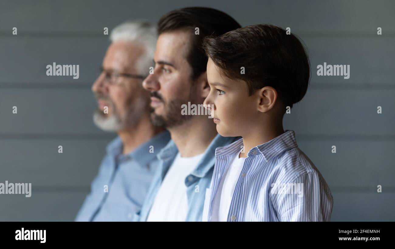 Three generations of Caucasian men look in distance Stock Photo