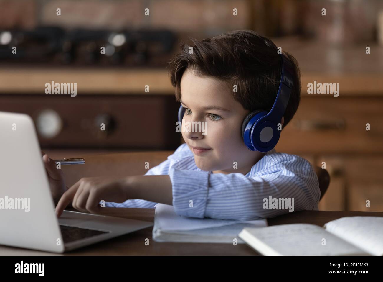 Small boy in headphones study on laptop online Stock Photo - Alamy