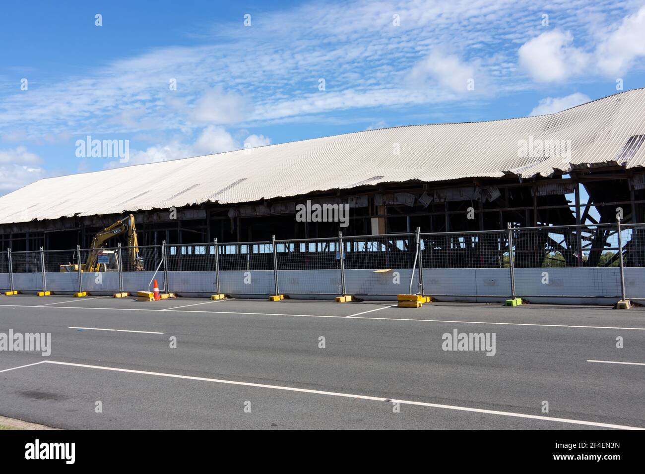 A line of temporary wire fencing with yellow concrete bases erected in front of a demolition site in a regional city. Stock Photo