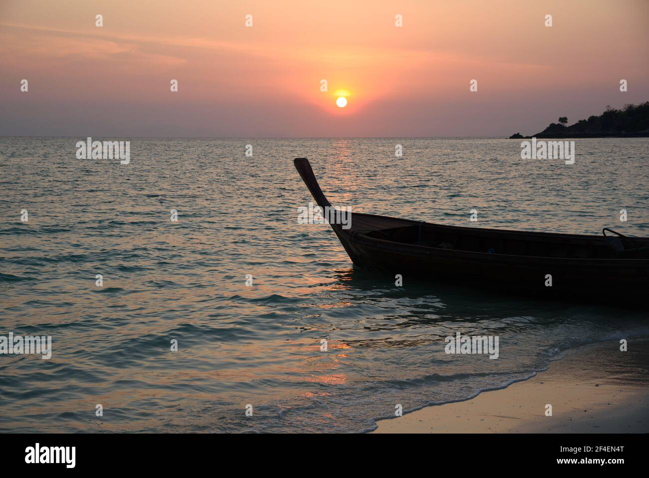 Scene of beautiful sunrise and silhouette of long tail boat at Lipe island, Satun province, Thailand. Stock Photo
