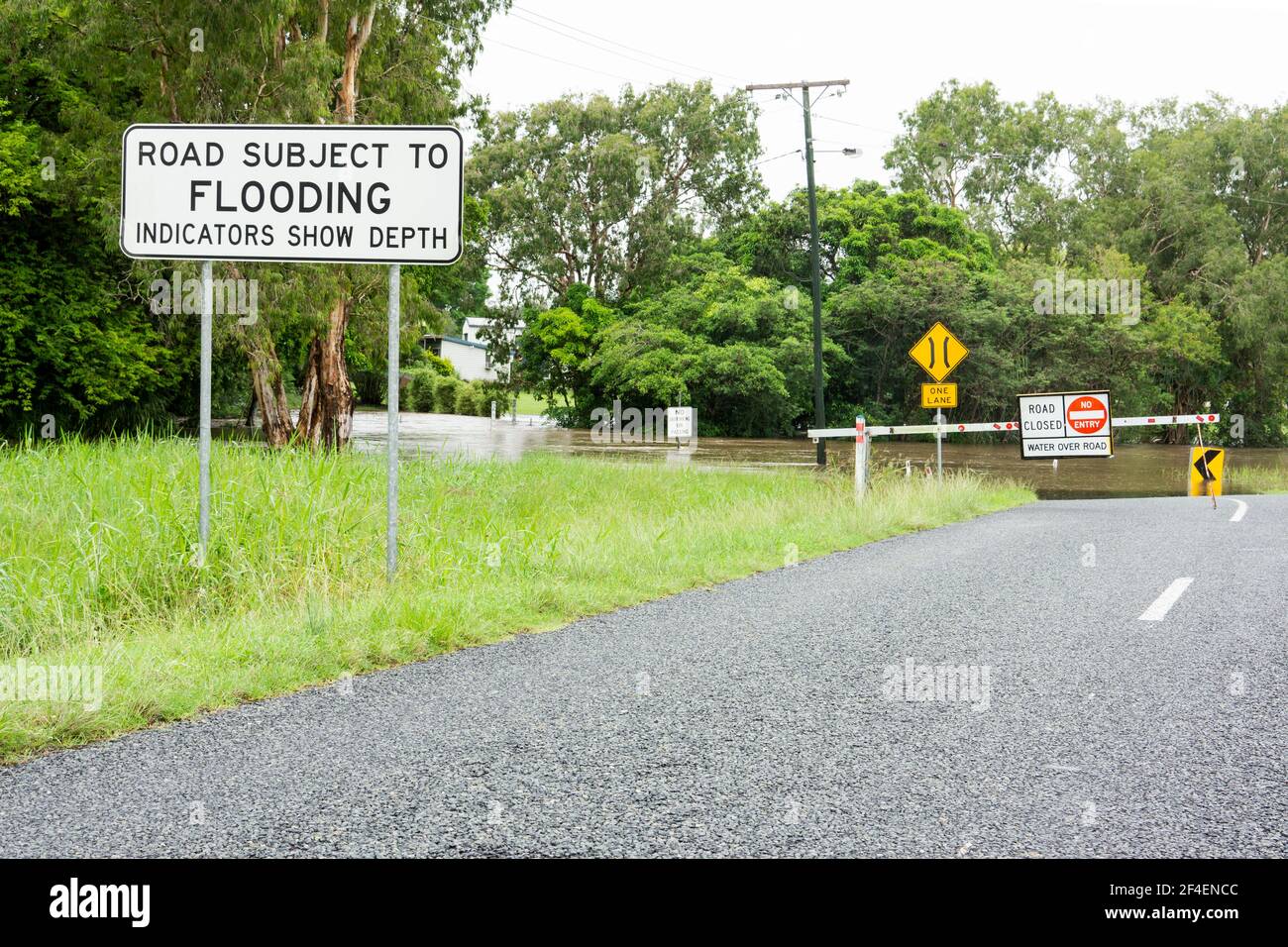 Warning sign that road is subject to flooding and a barrier and road