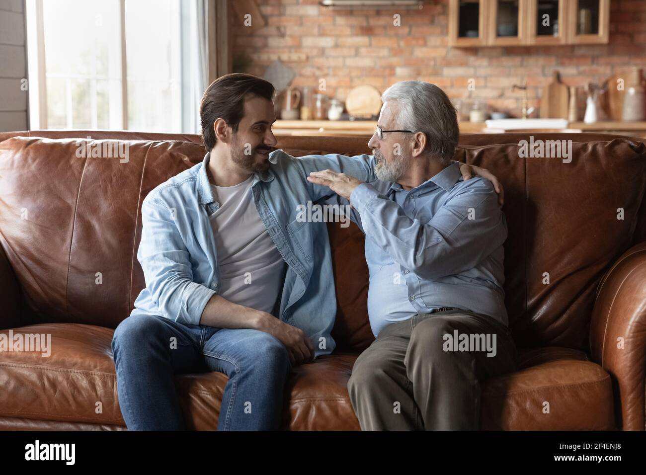 Mature father enjoy weekend talking with grownup son Stock Photo
