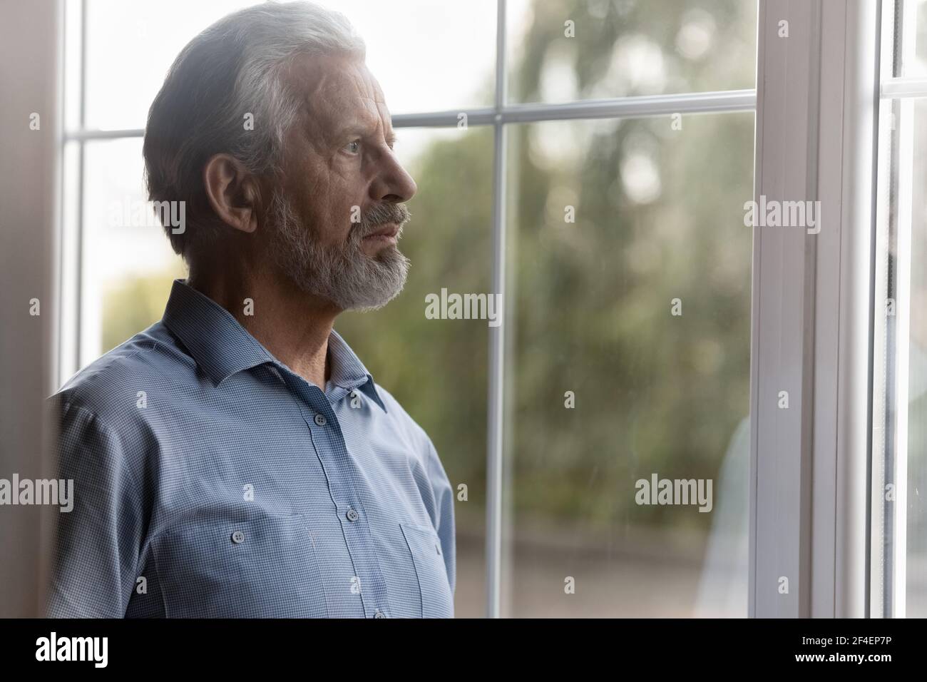 Unhappy elderly man look in distance missing Stock Photo