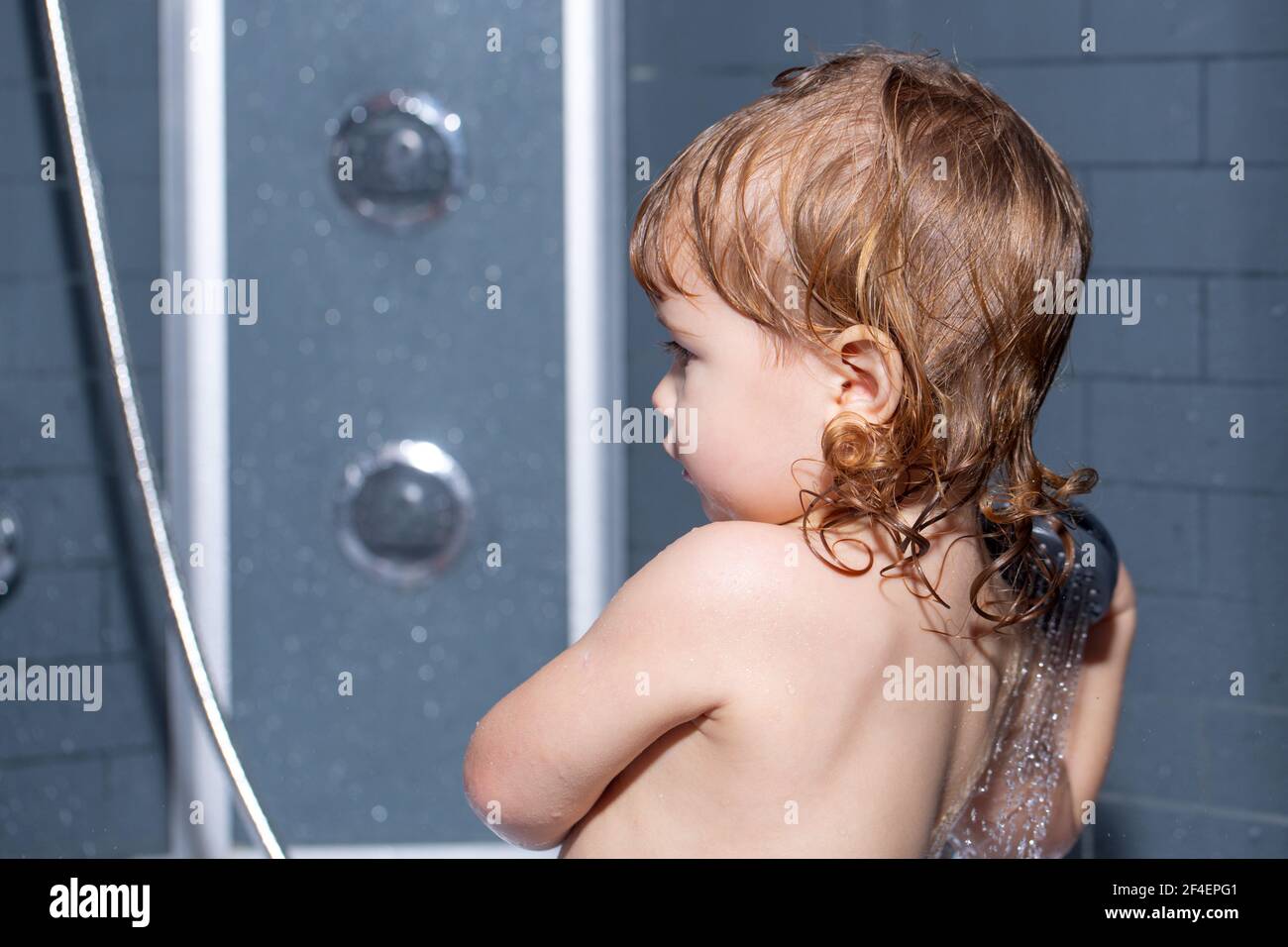 Toddler in a bathtub. Washing adorable baby in bathroom. Kid with soap