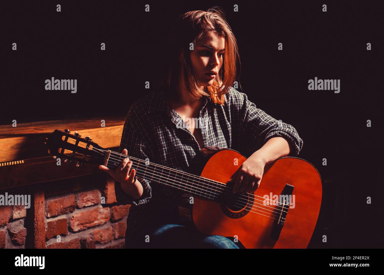 Woman playing guitar, holding an acoustic guitar in his hands. Girl play  the guitar. Woman hipster man sitting in a pub Stock Photo - Alamy