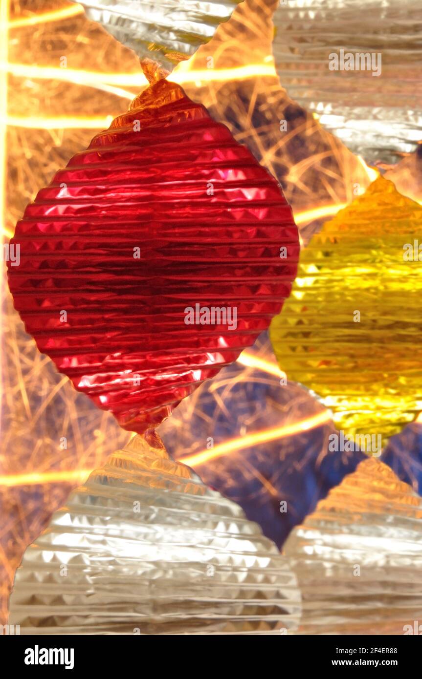 Partydekoration - hängende Spirale; im Hintergrund brennende Wunderkerze. Stock Photo